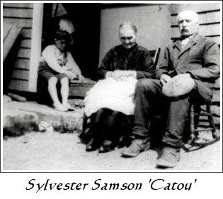 Sylvester Samson seated outside a house with family